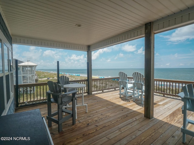 wooden terrace with a view of the beach and a water view