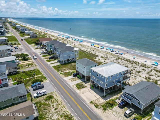 birds eye view of property with a water view and a beach view