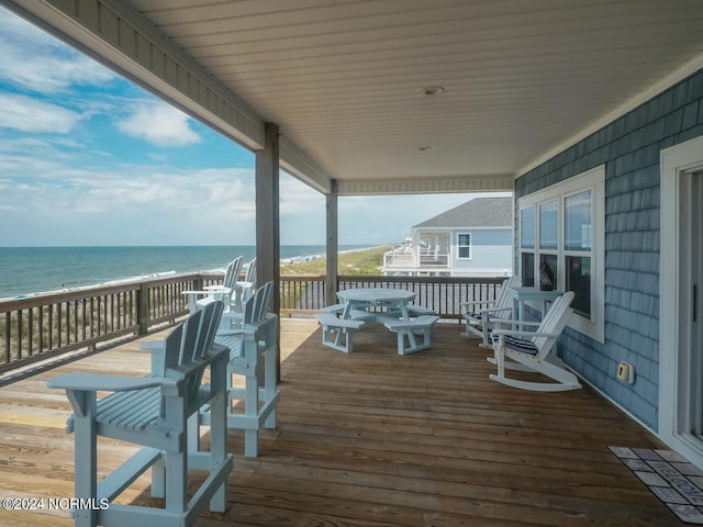 wooden terrace with a view of the beach and a water view