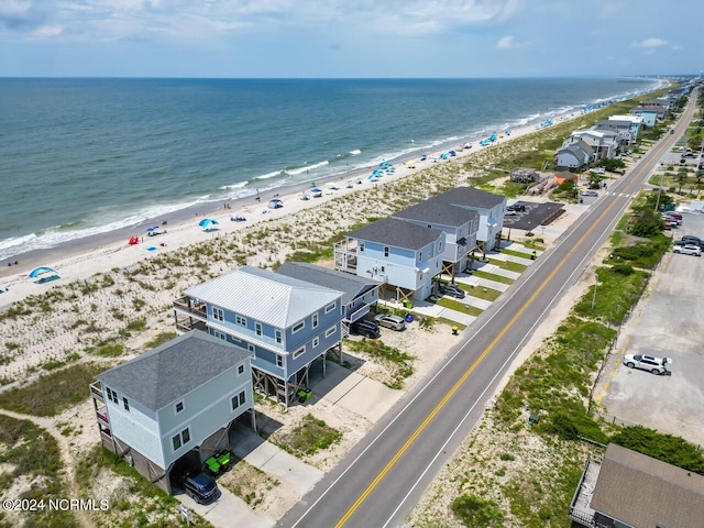 birds eye view of property with a water view and a beach view