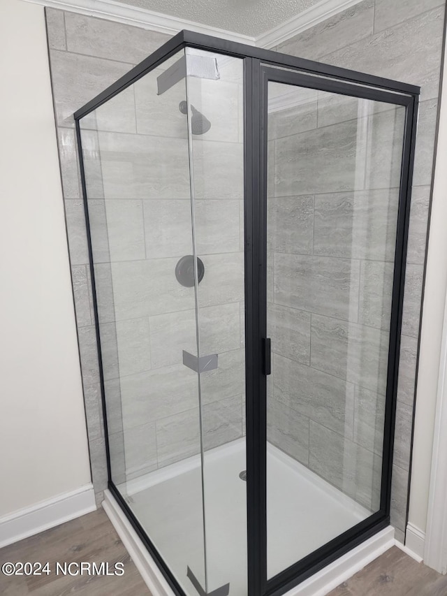 bathroom featuring a shower with shower door and hardwood / wood-style floors