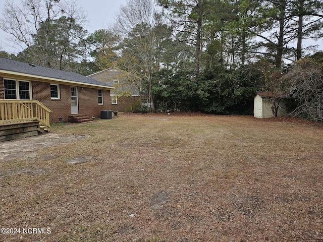 view of yard featuring a storage shed and central AC