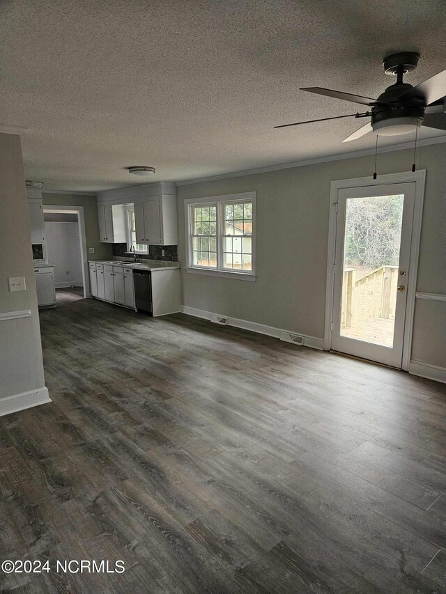 unfurnished living room with ceiling fan, sink, a textured ceiling, and hardwood / wood-style flooring