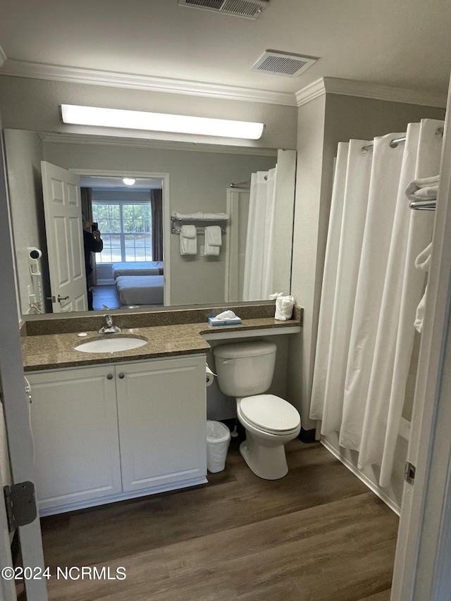 full bathroom featuring ornamental molding, wood finished floors, vanity, toilet, and a shower with curtain