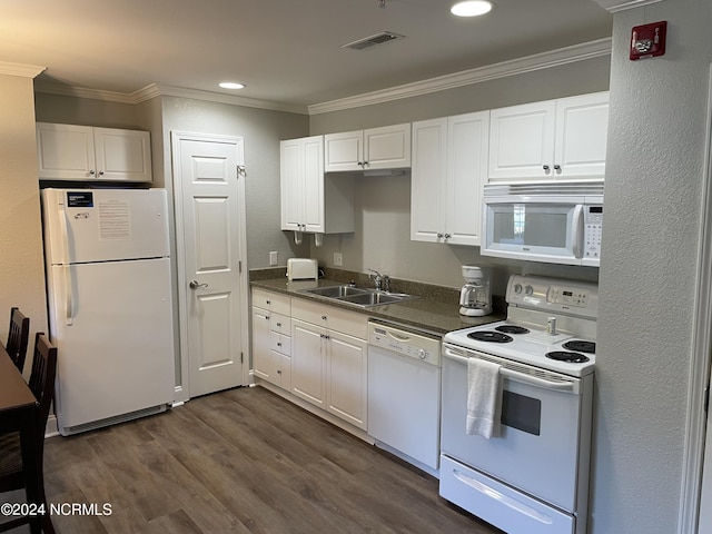 kitchen featuring white appliances, a sink, ornamental molding, dark countertops, and dark wood-type flooring