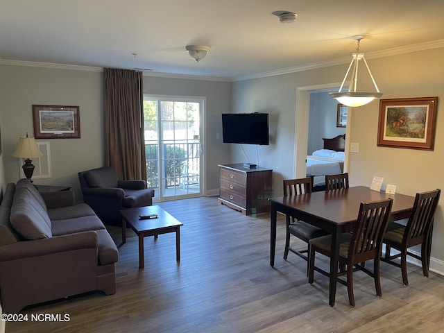 living area with wood finished floors, baseboards, and crown molding