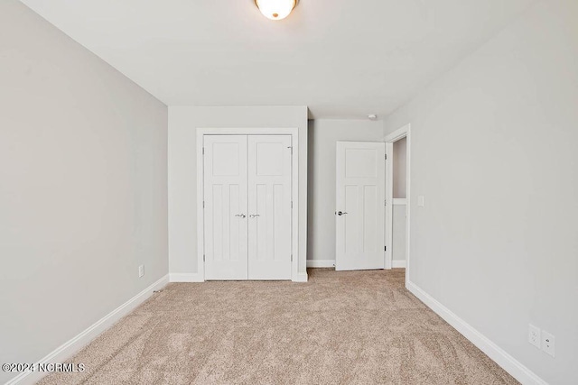 unfurnished bedroom featuring carpet floors and a closet