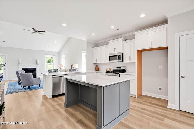 kitchen with a center island, white cabinetry, stainless steel appliances, sink, and kitchen peninsula