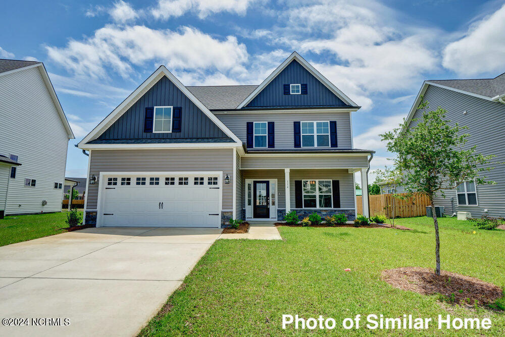 craftsman-style house with covered porch, a front yard, and a garage