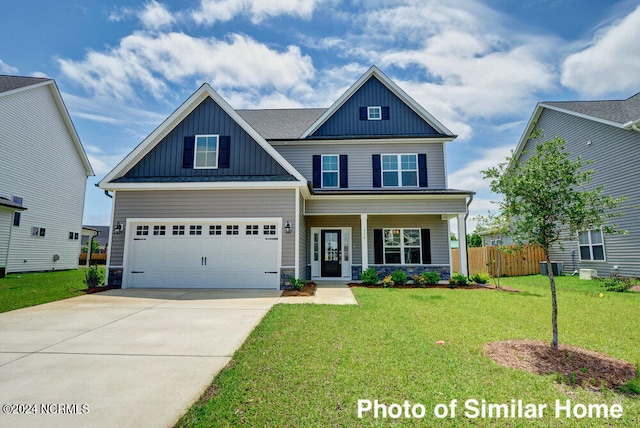 craftsman-style house with covered porch, a front yard, and a garage