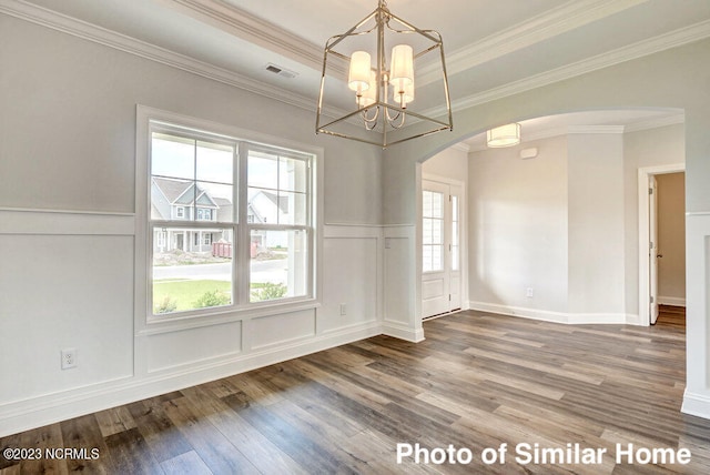 unfurnished dining area featuring ornamental molding, a tray ceiling, hardwood / wood-style floors, and a notable chandelier