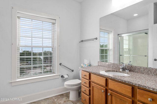 bathroom with an enclosed shower, vanity, and toilet