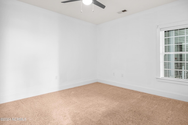 unfurnished room featuring ceiling fan and carpet