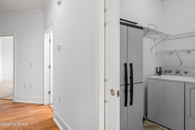 washroom featuring crown molding, hardwood / wood-style floors, and separate washer and dryer