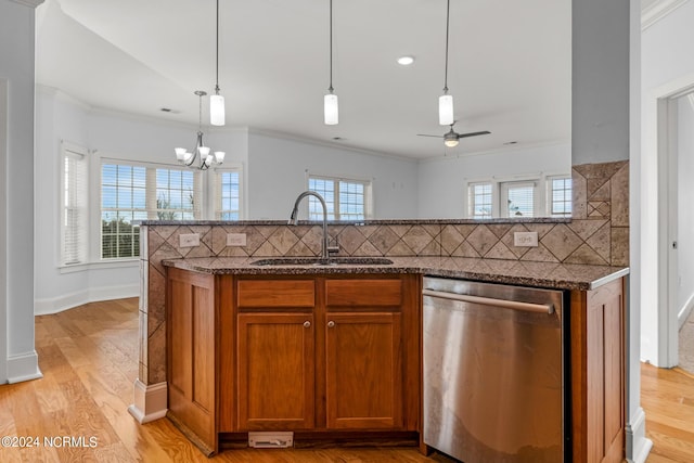 kitchen featuring light hardwood / wood-style floors, tasteful backsplash, stainless steel dishwasher, sink, and pendant lighting