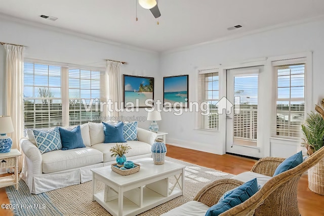 living room with light wood-type flooring, ceiling fan, and ornamental molding