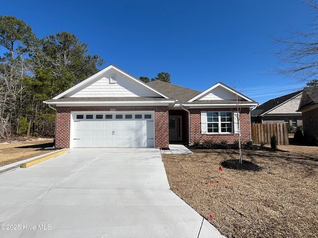 single story home featuring driveway, a garage, fence, and brick siding