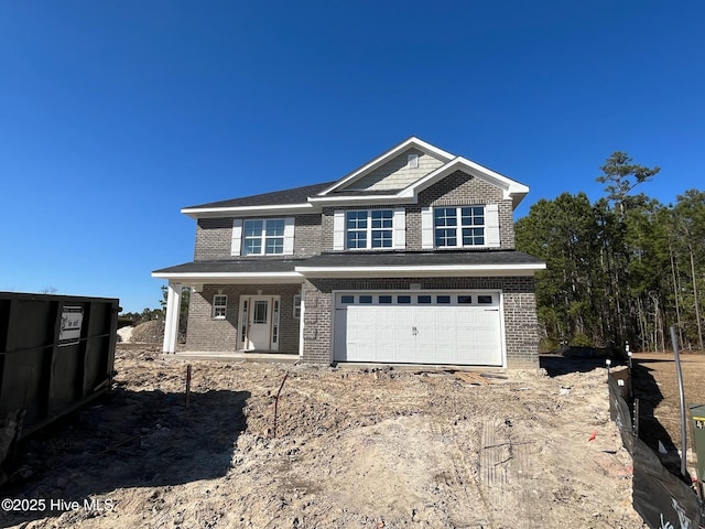 view of front of house featuring a garage, covered porch, and brick siding