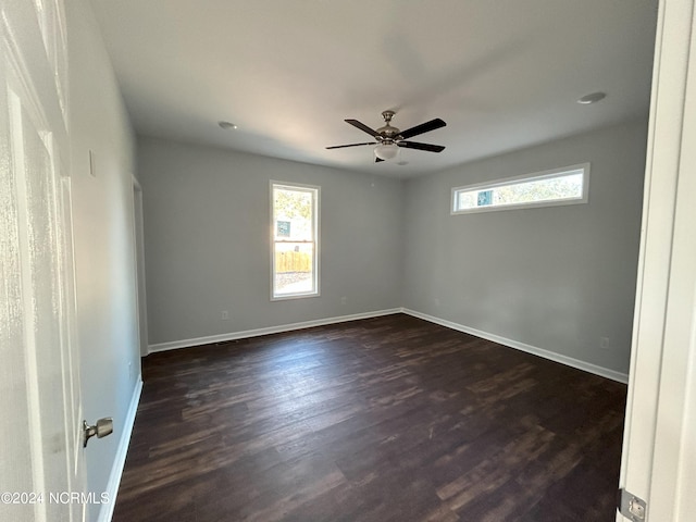 spare room featuring ceiling fan and dark wood-type flooring