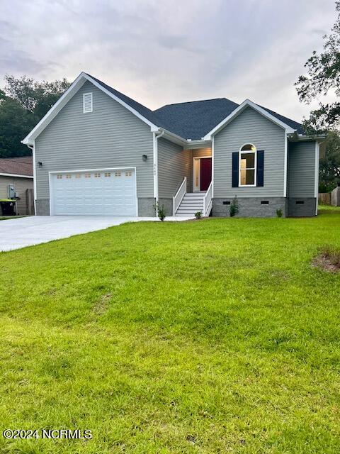 ranch-style home featuring a garage and a front lawn