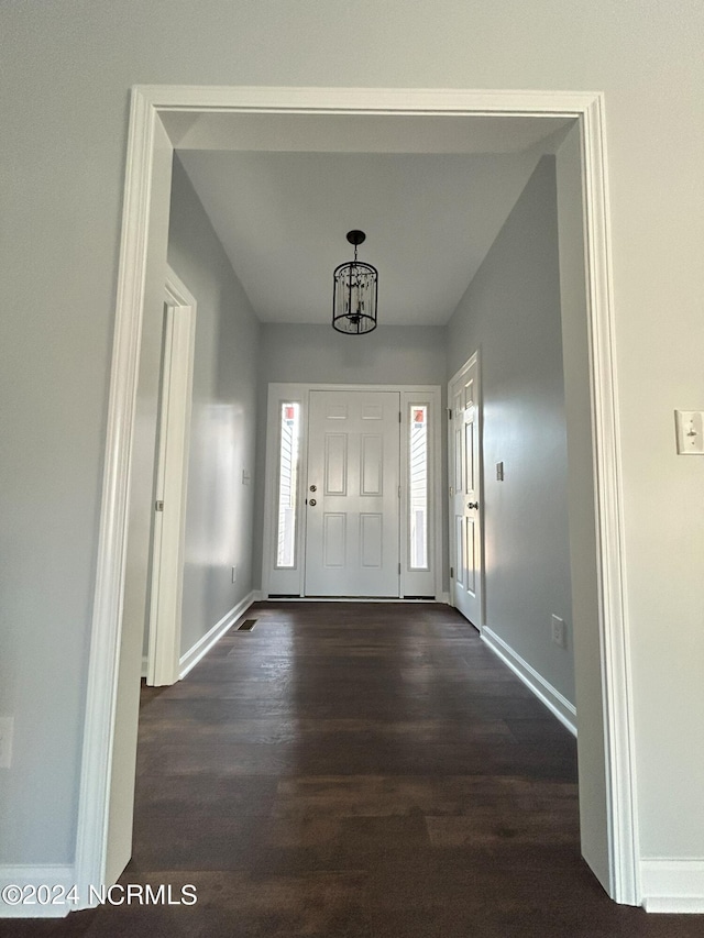 foyer featuring dark hardwood / wood-style flooring and a chandelier