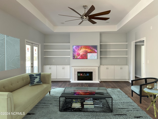 living room with built in shelves, french doors, and a tray ceiling