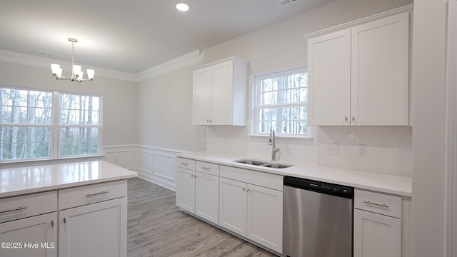 kitchen featuring ornamental molding, dishwasher, sink, and white cabinets