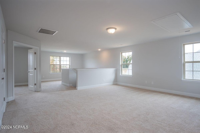 1224 Mandevilla Dr SE, Bolivia, NC 28422 - empty room featuring attic access, healthy amount of natural light, baseboards, and light colored carpet