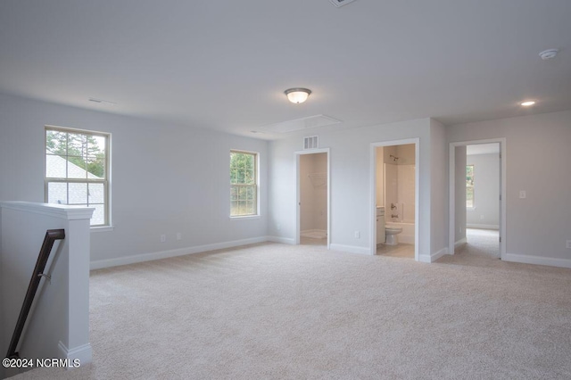 1224 Mandevilla Dr SE, Bolivia, NC 28422 - empty room featuring light carpet, attic access, and plenty of natural light