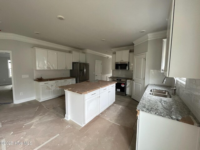 1224 Mandevilla Dr SE, Bolivia, NC 28422 - kitchen featuring appliances with stainless steel finishes, a sink, tasteful backsplash, a center island, and crown molding
