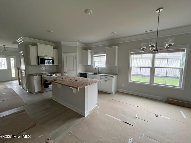 1224 Mandevilla Dr SE, Bolivia, NC 28422 - kitchen with stainless steel microwave, a sink, a chandelier, ornamental molding, and oven