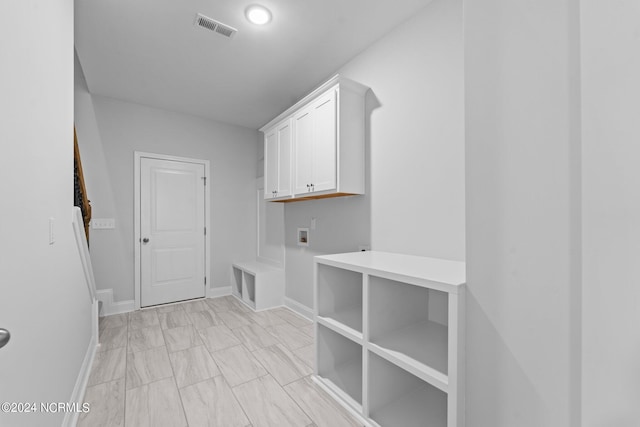 laundry room with hookup for a washing machine, visible vents, cabinet space, and baseboards