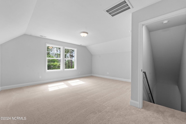 bonus room featuring light colored carpet and vaulted ceiling