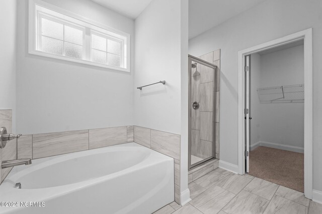 bathroom with tile patterned flooring and independent shower and bath