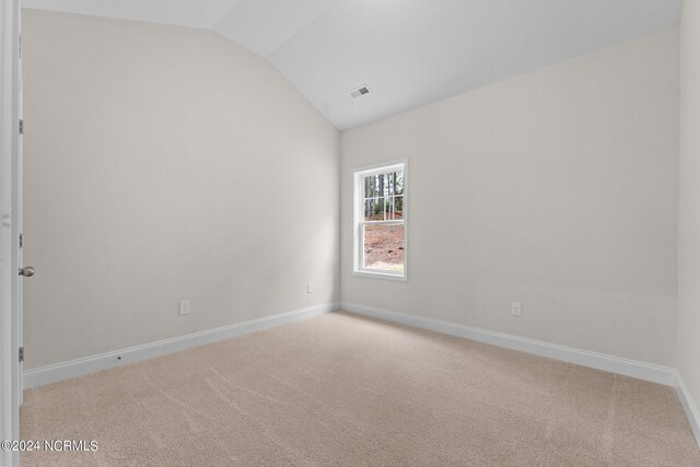 empty room with lofted ceiling and light colored carpet