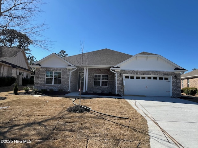 view of front of house featuring a shingled roof, brick siding, driveway, and an attached garage