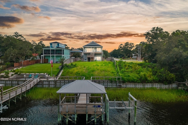 view of dock featuring a yard, a balcony, a gazebo, and a water view