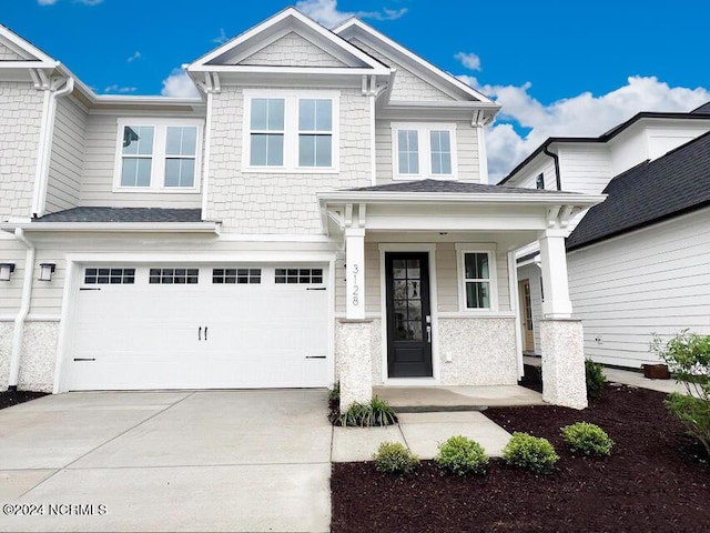 craftsman-style home featuring a garage, covered porch, and driveway