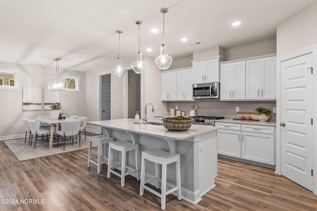 kitchen featuring white cabinetry, appliances with stainless steel finishes, light countertops, and decorative light fixtures