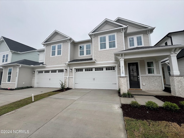 craftsman house featuring concrete driveway, covered porch, and an attached garage