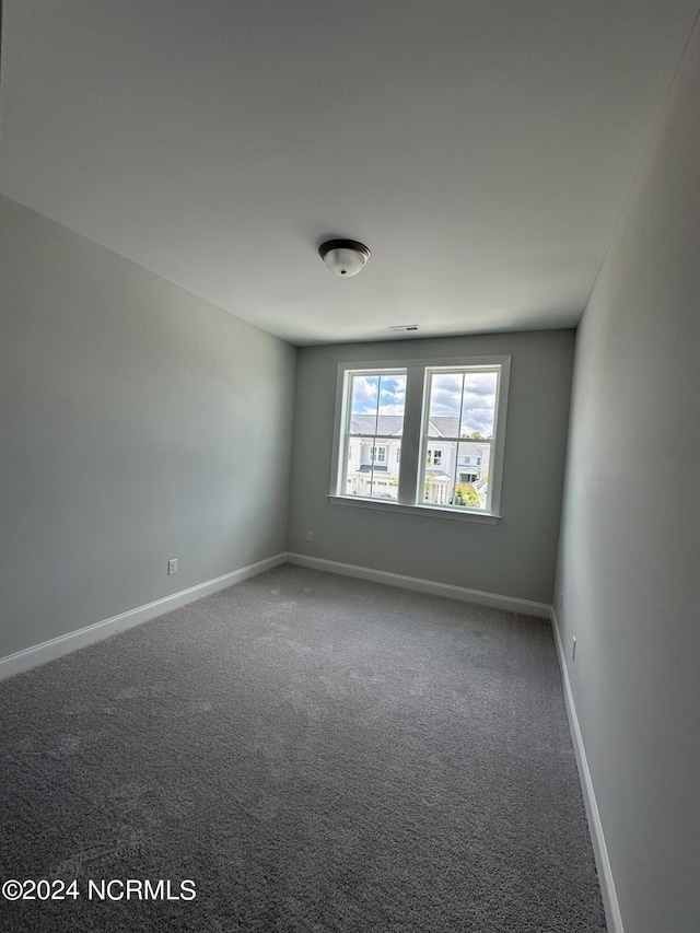 carpeted empty room with baseboards