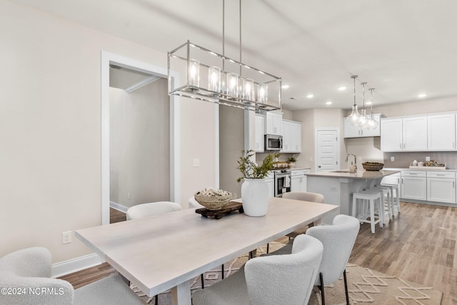 dining space with light wood-type flooring, baseboards, and recessed lighting