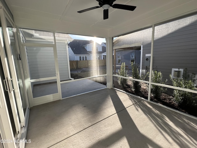 unfurnished sunroom featuring a ceiling fan