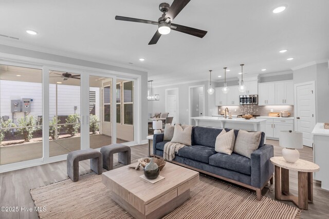 kitchen featuring dishwasher, white cabinets, a sink, and open floor plan