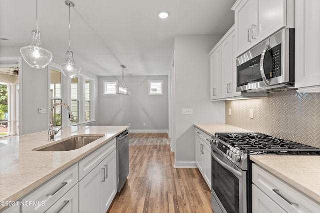 kitchen featuring light hardwood / wood-style flooring, a wealth of natural light, tasteful backsplash, and stainless steel appliances