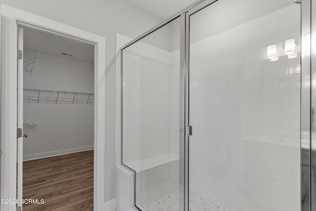 bathroom with wood-type flooring and an enclosed shower