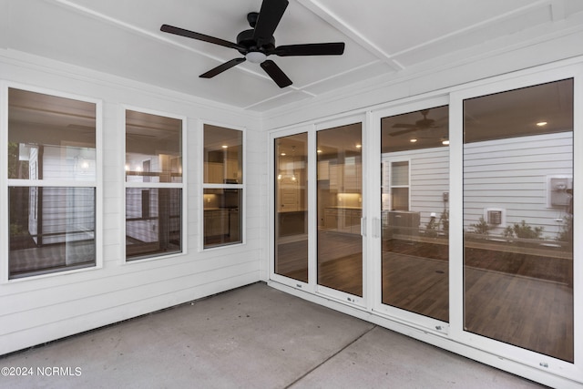 unfurnished sunroom with ceiling fan