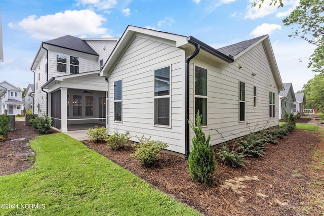 view of side of property featuring a lawn and a sunroom