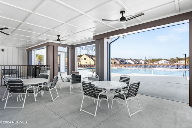 view of patio with a community pool and ceiling fan