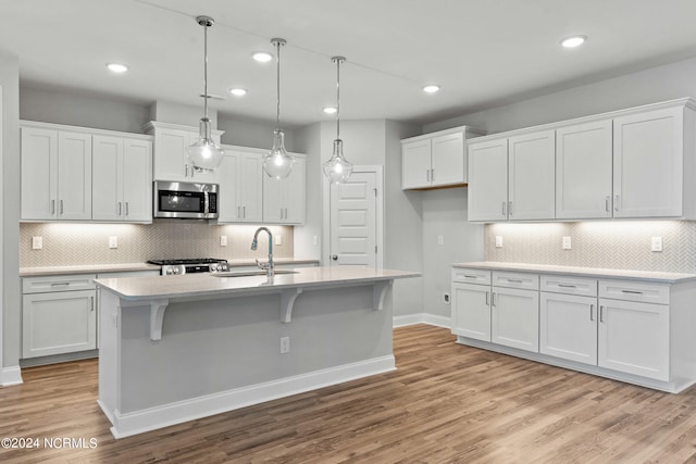 kitchen featuring white cabinetry, backsplash, and light wood-type flooring